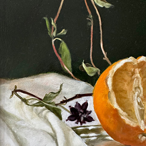 Detail of a still life oil painting of a cut orange on a silver plate against a dark green background with vines on a white tablecloth by Davette Leonard at Cottage Curator - Sperryville VA Art Gallery