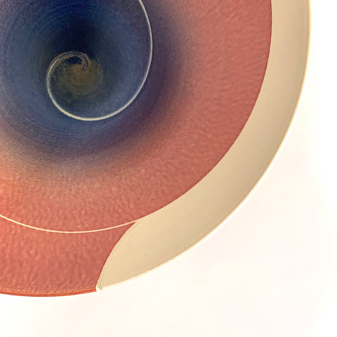 Detail of tapered porcelain bowl with ivory exterior and spiral center design glazed in pink/orange and blue/purple by Wayne Bates at Cottage Curator - Sperryville VA Art Gallery