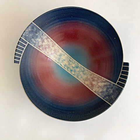 Top view of tapered porcelain bowl with spiral, symmetrical center design glazed in blue, red and green with ivory carving across the center by Wayne Bates at Cottage Curator - Sperryville VA Art Gallery