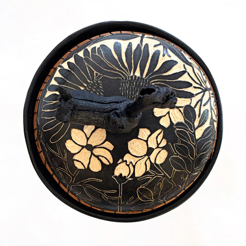 Top view of lidded black and white ceramic vessel with pine needle rim and grapevine lid handle showing a portrait of a chickadee surrounded by plants, carved in sgraffito by Carolyn Blazeck, at Cottage Curator - Sperryville VA Art Gallery