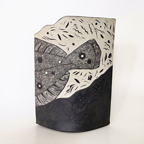 Vase with carving of flounder with tail visible in black and white by Shirley Gromen